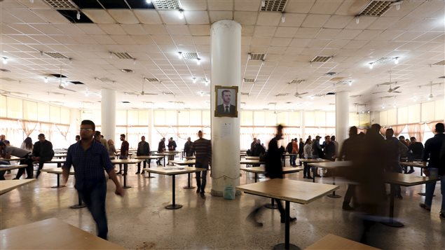 مركز اقتراع في دمشق خلال سير الانتخابات التشريعية يوم أمس، وتبدو في الوسط صورة للرئيس بشار الأسد على أحد الأعمدة.