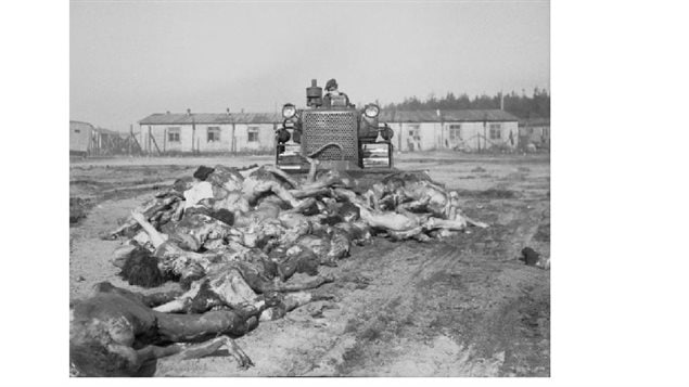 Unimaginable horror: a British army bulldozer has to push bodies into a mass grave at the camp, April 19, 1945.