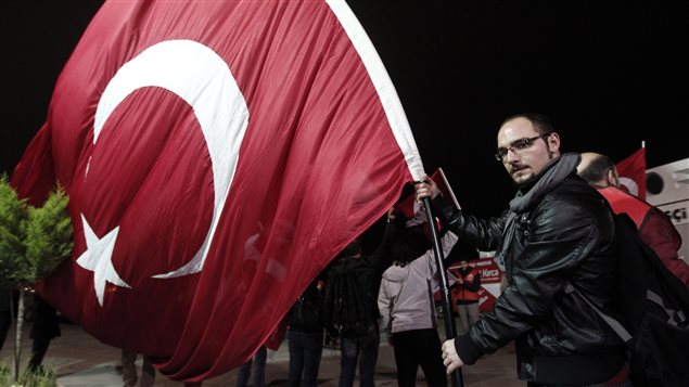 Un manifestant en faveur du laïcisme arbore un drapeau turc, en attendant la libération du général à la retraite Ilker Basbug en mars 2014, près d'Istanbul. Un manifestant en faveur du laïcisme arbore un drapeau turc, en attendant la libération du général à la retraite Ilker Basbug en mars 2014, près d'Istanbul.