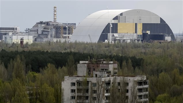  A containment shelter for the damaged fourth reactor (L) and the New Safe Confinement (NSC) structure (R) at the Chernobyl Nuclear Power Plant are seen from Ukraine’s abandoned town of Pripyat, Ukraine, April 22, 2016.