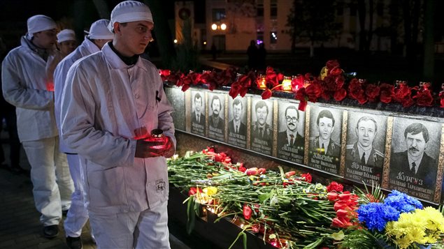 Empleados de la central nuclear de Chernóbil, ponen flores enel memorial de los bomberos que perdieron la vida después de la explosión.