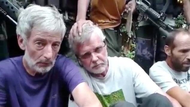 Canadians Robert Hall (left) and John Ridsdel (middle) and Norwegian Kjartan Sekkingstad appear at gunpoint in a Abu Sayyaf video appealing to the Philippines government to stop military operations. 