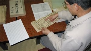 The Priest-Mr.Kiyoshi Miyasaki pointing out some of the records on lake ice and the omiwatari. His data sheet summarizing the records are on the table.-(Nov-3-2005)