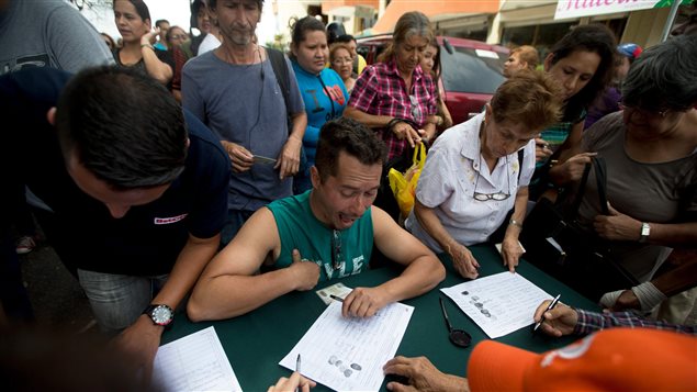 La oposición venezolana comenzó, hoy, la primera etapa de recolección de firmas para tratar de convocar un referendo revocatorio del mandato del actual presidente Nicolás Maduro. En la foto: personas firmando en San Cristobal. 