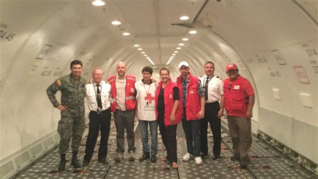 La embajadora Marianick Tremblay, acompañada por Gabriel Frappier (con gorro blanco) en el avión cargo de la Cruz Roja canadiense que llegó con un hospital móvil de las Fuerzas Armadas Canadienses. Rodeados por representantes de la Cruz Roja canadiense y ecuatoriana, de fuerza aérea de Ecuador y miembros de la tripulación.