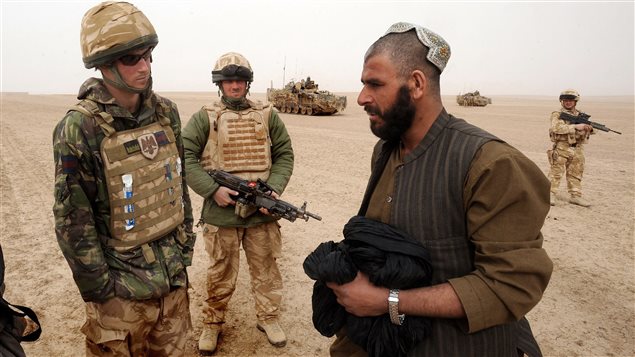  Britain’s Prince Harry (L) directs an Afghan man around a British Army cordon, with the help of an Afghan interpreter, in the desert in Helmand province in Southern Afghanistan February 21, 2008. 