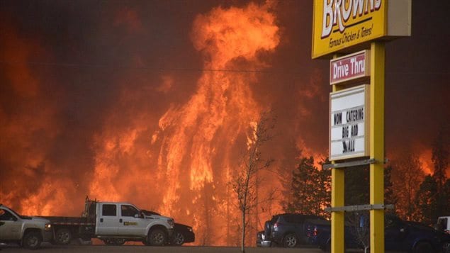  A wall of fire rages outside of Fort McMurray, Alta. Tuesday May 3, 2016. Raging forest fires whipped up by shifting winds sliced through the middle of the remote oilsands hub city of Fort McMurray Tuesday, sending tens of thousands fleeing in both directions and prompting the evacuation of the entire city. 
