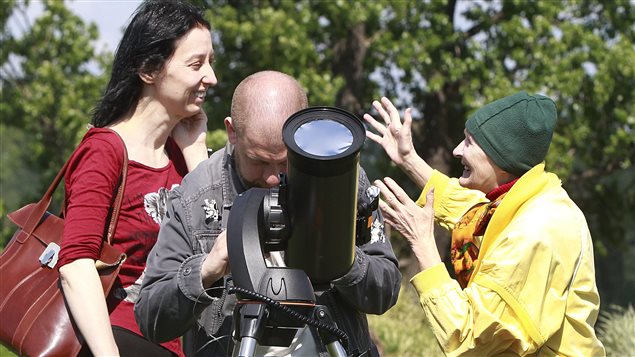  A man watches through a specially secured telescope as planet Mercury passes against the sun in a rare astronomical occurrence in front of the Copernicus Science Center in Warsaw, Poland, Monday, May 9, 2016.