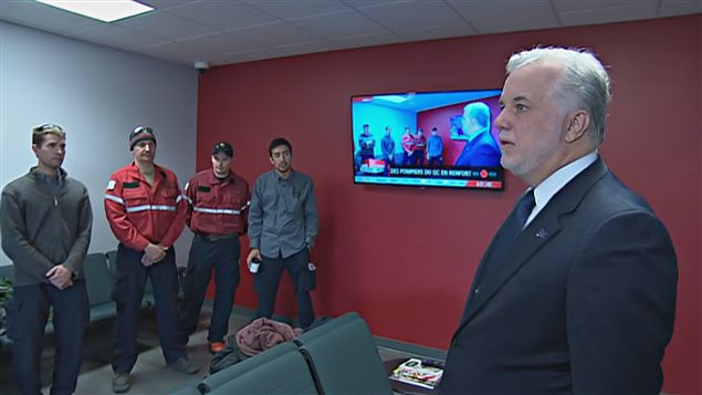 El primer ministro de Quebec, Philippe Couillard, saludando a los bomberos que viajan a Alberta.