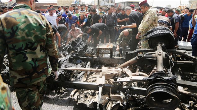 مواطنون في مدينة الصدر في بغداد متجمعون أمس بعد انفجار سيارة مفخخة. 