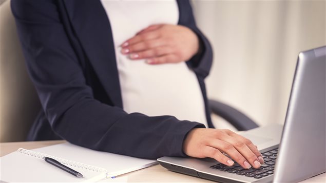Une femme enceinte qui travaille sur son ordinateur. Une femme enceinte qui travaille sur son ordinateur.