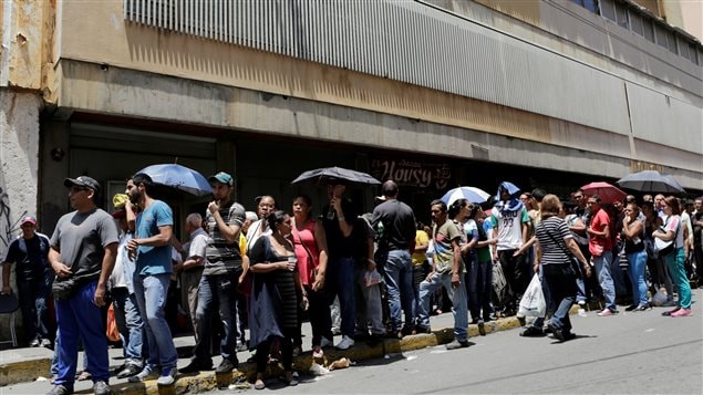 Gente haciendo cola para comprar productos de primera necesidad en Caracas, Venezuela.