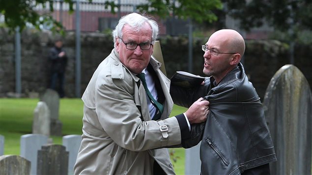 Kevin Vickers (izq.) expulsa a manifestante en ceremonia Dublin, Irlanda.