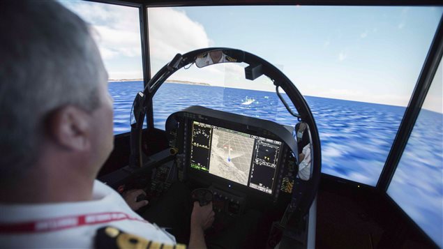  Navy Captain Wade Carter, Director of Navy Requirements, lands a simulator of a Boeing F/A-18 Super Hornet at the Canadian Association of Defence and Security Industries’ CANSEC trade show in Ottawa on Wednesday, May 27, 2015. 