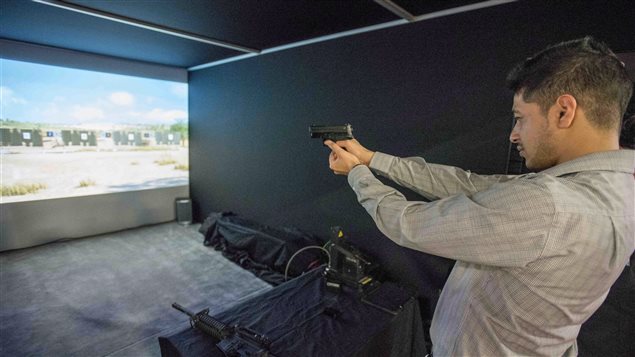  A delegate tries his hand at a realistic weapons simulator during the Canadian Association of Defence and Security Industries’ CANSEC trade show in Ottawa on Wednesday, May 27, 2015. 