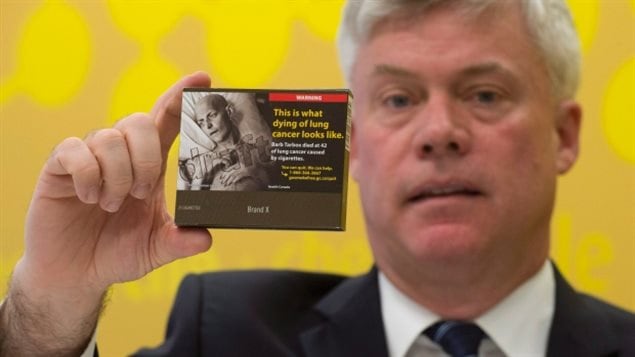 Rob Cunningham, senior policy advisor for the Canadian Cancer Society, holds up a proposed standardized cigarette package. The federal government is holding public consultations to develop new regulations on cigarette packaging. 