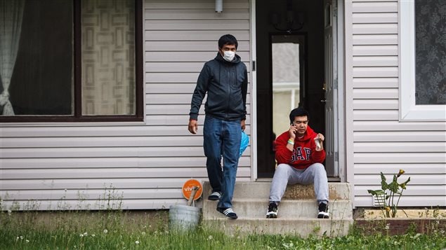 James Turingan (gauche) et Russell Boston (droite) constatent les dégâts provoqués par le feu dans leur maison de Fort McMurray.