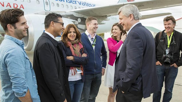 Stephen Harper discute avec des journalistes sur le tarmac pendant la campagne électorale à Rivière-du-Loup en septembre 2015