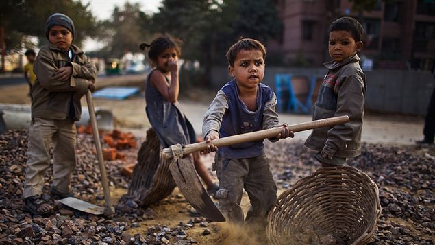 Children work near their parents at a construction site in New Delhi, India on January 30, 2010.