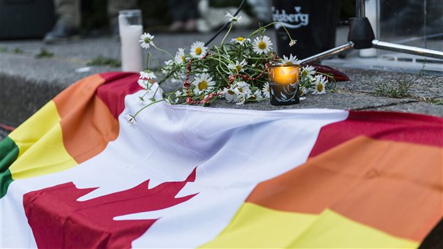 Les drapeaux du Canada et de la communauté gaie se côtoyaient, dimanche, lors d’une vigile en mémoire des victimes de la tuerie d’Orlando organisée à Toronto.
