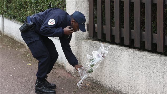 Un policía francés deja flores en homenaje a sus dos colegas asesinados, ayer, en Magnanville, al oeste de Paris. Según el presidente francés, François Hollande, el ataque fue “incontestablemente un acto terrorista”       