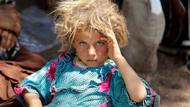  A girl from the minority Yazidi sect, fleeing the violence in the Iraqi town of Sinjar, rests at the Iraqi-Syrian border crossing in Fishkhabour, Dohuk province August 13, 2014.