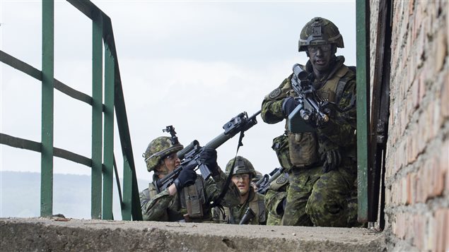  Sergeant Marco Tremblay, Corporal Benoit Seguin-Perron and Corporal Jean-Guillaume Bibeau, members from 1st Battalion, Royal 22e Régiment, advance toward a building during a joint training scenario organized as part of Exercise ANAKONDA in Wedrzyn, Poland on June 14, 2016.