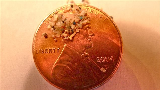 Microbeads shown in scale against a typical one-cent coin
