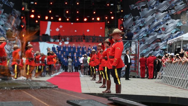 Members of the Royal Canadian Mounted Police salute during singing of the national Anthem at Canada Day celebrations in Ottawa