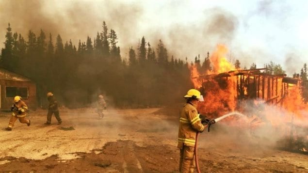 Des pompiers combattant l’énorme feu de forêt qui a ravagé la ville de Fort McMurray en Alberta en mai 2016.