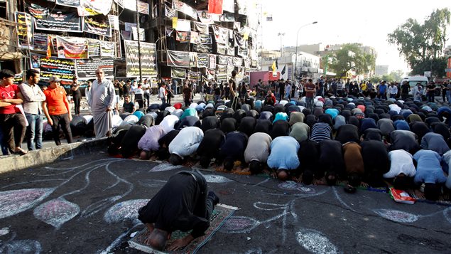 مسلمون من السنة والشيعة يصلون معاً اليوم في موقع التفجير الانتحاري الذي ضرب ليل السبت الأحد حي الكرّادة في بغداد وتجاوزت حصيلته حتى الآن 250 قتيلاً عدا الجرحى. 