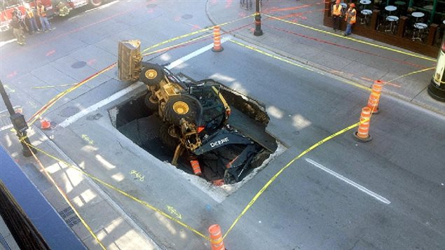 Responding to a reported pipe leak, this backhoe was swallowd by a sinkhole as the road collapsed beneath it as it moved into position to excavate. Leaky pipes cost millions of dollars for cities in wasted water, and in damage repair costs