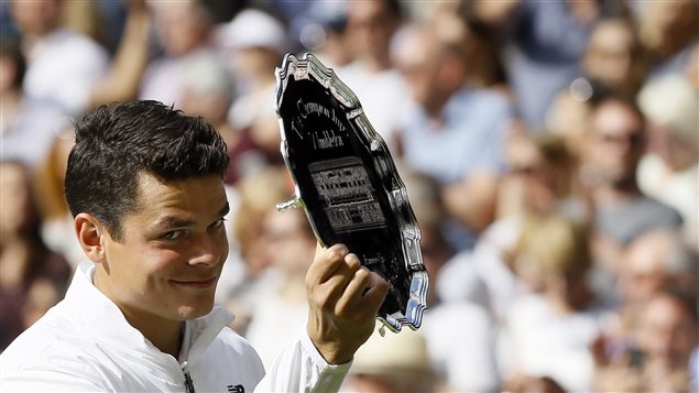 "Not bad, eh?" Milos Raonic holds his runner's up trophy after being beaten by Scotland's Andy Murray in the Wimbledon men's singles on Sunday. We see Raonic at the left of the picture. He is holding up the runner's up plate with his right hand. He is no longer sweating (to watch him play one wonders if he ever sweats) and looking at the camera through eyes pressed to his right. His mouth hovers between a smile and a grimace, but the expression appears to say, "Not bad, eh?" But I may be projecting.