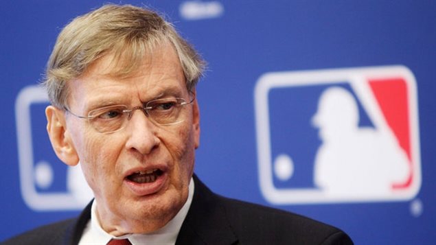 The face that launched a thousand (meaningless) hits. MLB Commissioner Bud Selig insituted the rule that sees the winners of the All-Star Game assured of home field advantage in the World Series back in 2003 after the teams ran out of players the year before and the game had to be called. We see Selig from the shoulders up. He appears to be answering a question as his mouth is open. His blondish (and dyed) hair is thinning and parted on the left. He wears rimless glasses.