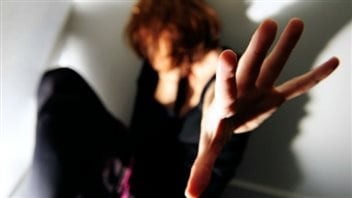 Approximately every six days in Canada, a woman is killed by her intimate partner. We see a woman backed into a corner stretching out her hands in defence to protect herself.