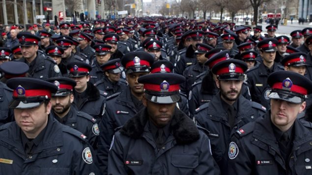 Des policiers de Toronto avec des agents noirs à l’avant plan. (Chris Young/Canadian Press)