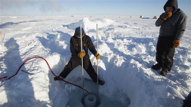 Applied Physics Laboratory Ice Station (APLIS) employee Keith Magness (L) and Nick Michel-Hart cut a hole in the Arctic ice to hang sonar instrumentation for research at the 2011 Arctic APLIS camp north of Prudhoe Bay, Alaska March 18, 2011. 