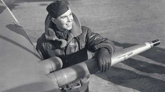 Flight Lt Charley Fox leaning on the wing of his Spitfire with its 20mm cannon
