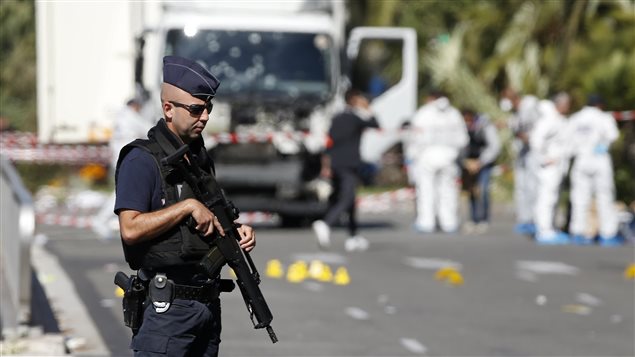Un policier monte la garde alors que l’enquête se poursuit autour du camion qui a foncé dans la foule rassemblée sur la Promenade des Anglais à Nice lors de la fête nationale. 