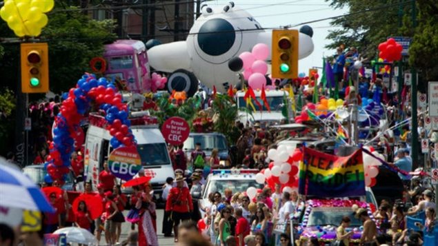  All was peace and love at the Vancouver Pride parade in 2011. Who marches this year is cause for some controversy. We see a long shot of thousands of people dressed in colourful costumes marching through the streets of Vancouver, waving balloons and celebrating.