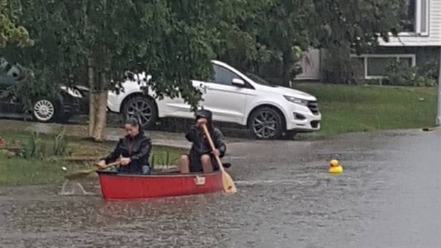 Des résidents à bord d’une barque pendant les inondations à Fort McMurray.