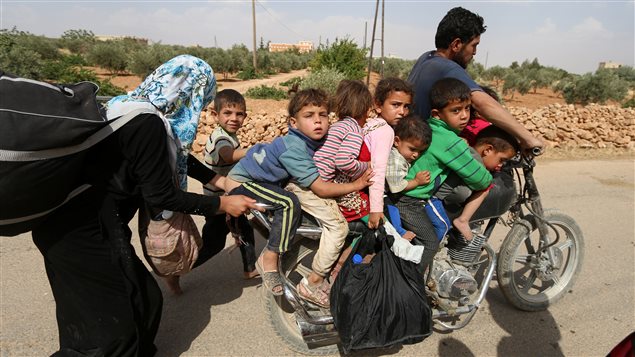 عائلة سورية تهرب من جحيم المعارك في محيط حلب الصيف الفائت.