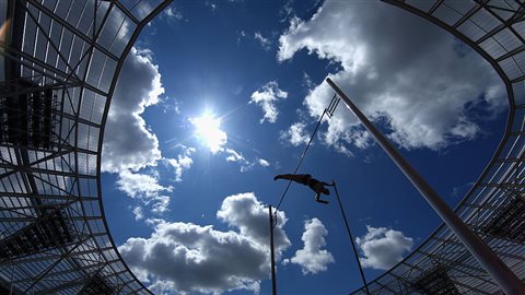 From this dreams are made. Shawn Barber (above, at the Sainsbury's Anniversary Games in England last summer) is the reigning pole vault champion, and hopes to repeat his victory at the 2015 Athletics World Championships in Beijing last year at this year's Rio Olympics. We look high upward at the silhouette of a man soaring through the air below a bright blue sky filled with grey and white cumulus clouds.