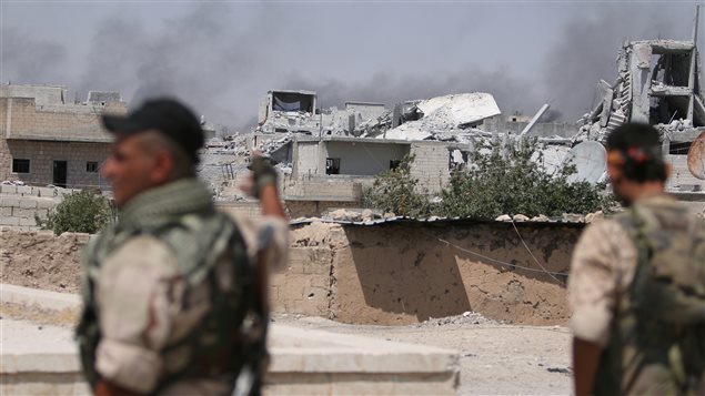 جنود سوريّون وسط الدمار في مدينة حلب