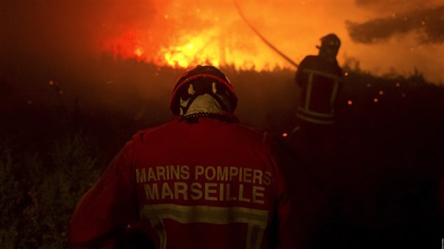 Bomberos de Marsella tratan de limitar el avance de las llamas.