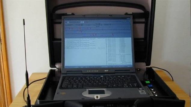 StingRays intercept cellphone connections to communications towers to scoop data from every phone or device in a geographical area. Vancouver police have admitted to using one nine years ago. We see a computer keyboard and open computer screen inside a James Bondish travel case. It sits on a table with an ariel standing next to it.