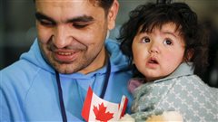Un réfugié syrien et sa fille lors de leur arrivée à Toronto, en décembre 2015 Un réfugié syrien et sa fille lors de leur arrivée à Toronto, en décembre 2015