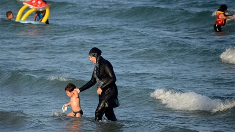 Une femme en burkini se baigne.