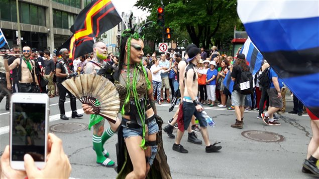 Muchos acuden a sus teléfonos móviles para capturar el despliegue visual del desfile.