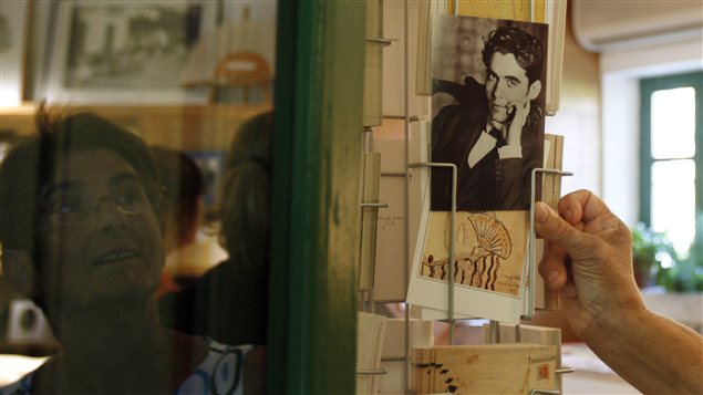 Una mujer mira una postal con la foto de Federico Garcia Lorca en una tienda de Grenada en España.